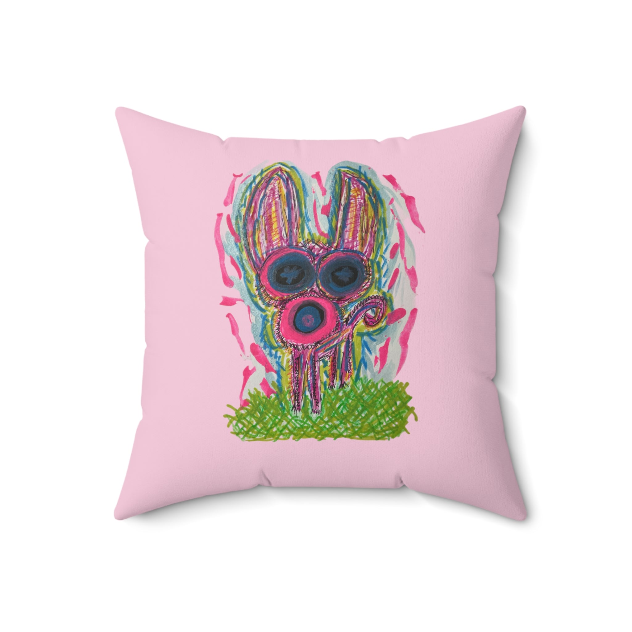 A square pink throw pillow featuring a colorful, textured graphic of a rabbit wearing round sunglasses and standing on green grass, set against a plain white background.