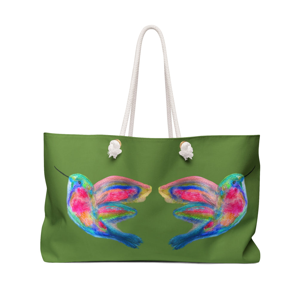A green tote bag with white rope handles, featuring a colorful watercolor-style print of two hummingbirds on the front. Beautiful birds. 