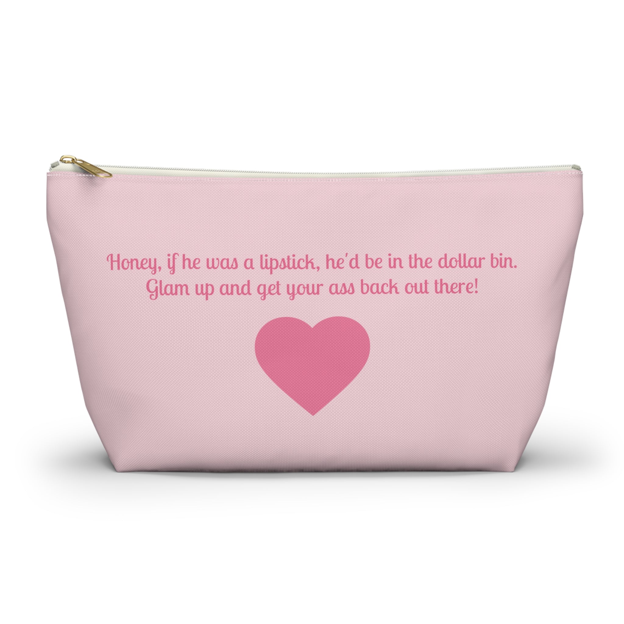 A light pink cosmetic pouch with a gold zipper, featuring a pink heart and a humorous quote printed on the front, set against a plain white background.